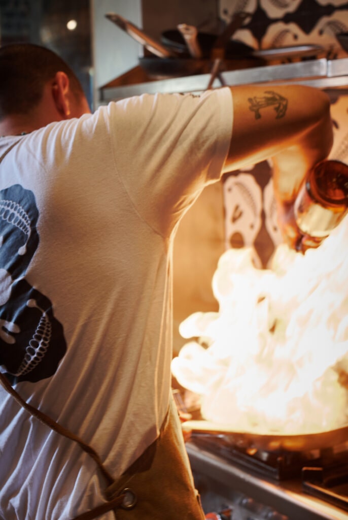 Cocinero flambeando en la cocina