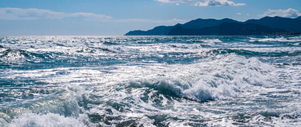 El mar en Castelldefels con las montañas al fondo